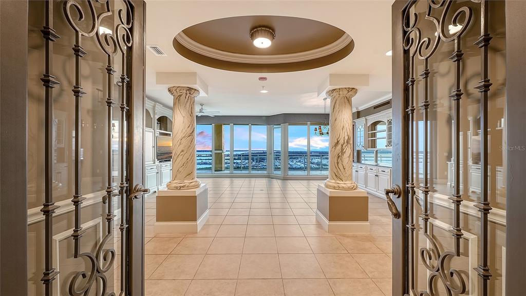 A room with marble columns, tile flooring, and a circular tray ceiling overlooking a marina — 140 RIVIERA DUNES WAY UNIT 1204, PALMETTO, FL