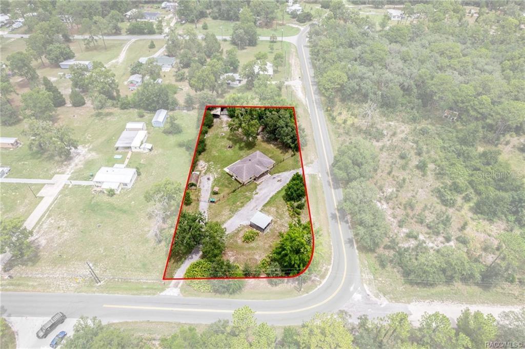 An aerial view shows a house and outbuilding on a lot outlined in red — 6185 W OST WEST STREET, HOMOSASSA, FL