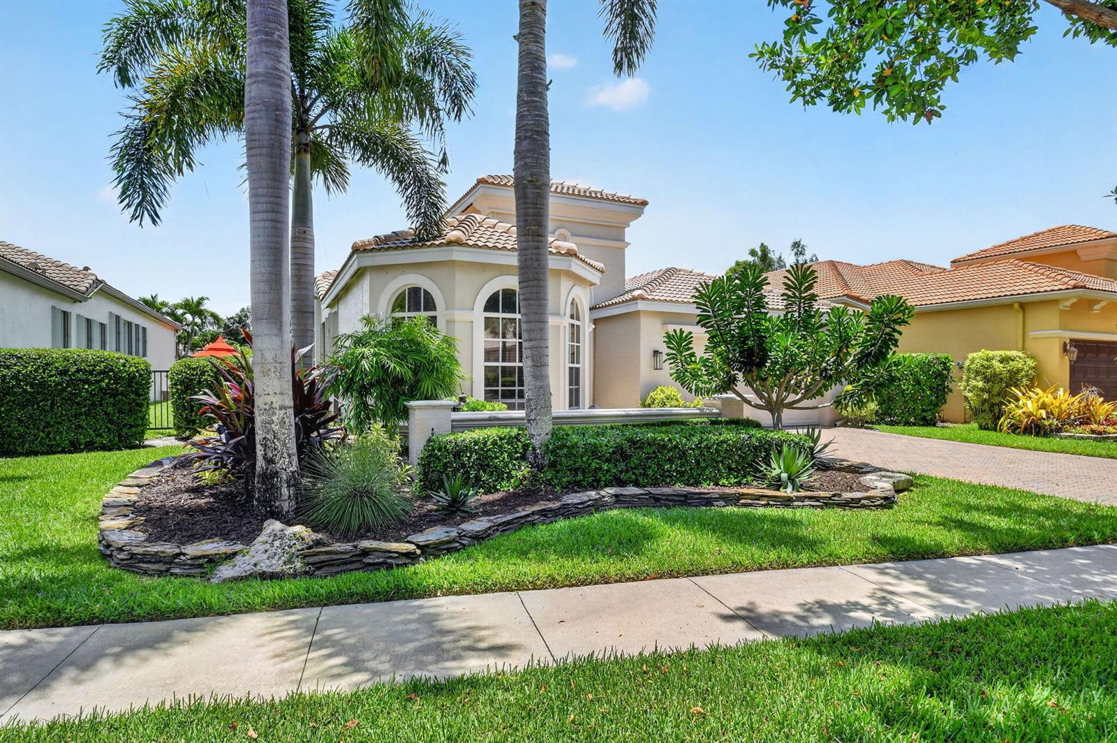 A single-story house with a tile roof, arched windows, and a landscaped front yard — 9774 Via Elegante, Wellington FL 33411, WELLINGTON, FL