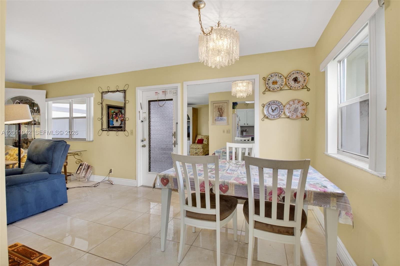 A dining area with a table, white chairs, tile floors, and yellow walls — 537 Brittany L # 537, Delray Beach FL 33446, DELRAY BEACH, FL