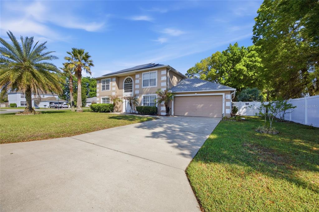 A two-story house with a beige exterior, a concrete driveway, and a two-car garage — 4517 SE 28TH STREET, OCALA, FL