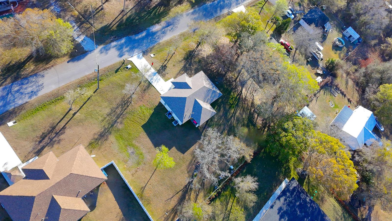 An aerial view shows a residential property with a house, driveway, and surrounding trees — 7757 NW 82nd Court, Okeechobee FL 34972, OKEECHOBEE, FL