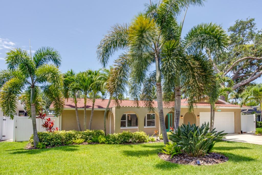 A single-story house with a tan stucco exterior, a red roof, and several palm trees — 14060 82ND AVENUE, SEMINOLE, FL