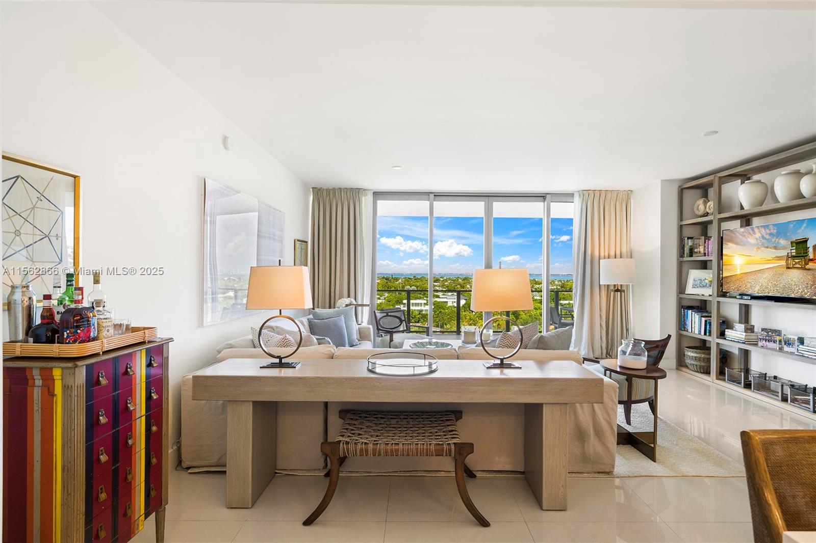 A living room features a sofa, console table, colorful cabinet, and a large window view — 360 Ocean Dr # 905S, Key Biscayne FL 33149, KEY BISCAYNE, FL