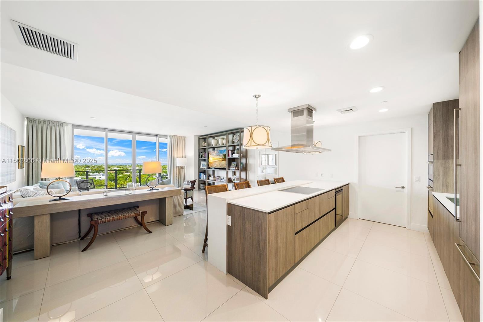 A modern open-concept kitchen and living area with wood cabinetry, white countertops, and floor-to-ceiling windows — 360 Ocean Dr # 905S, Key Biscayne FL 33149, KEY BISCAYNE, FL