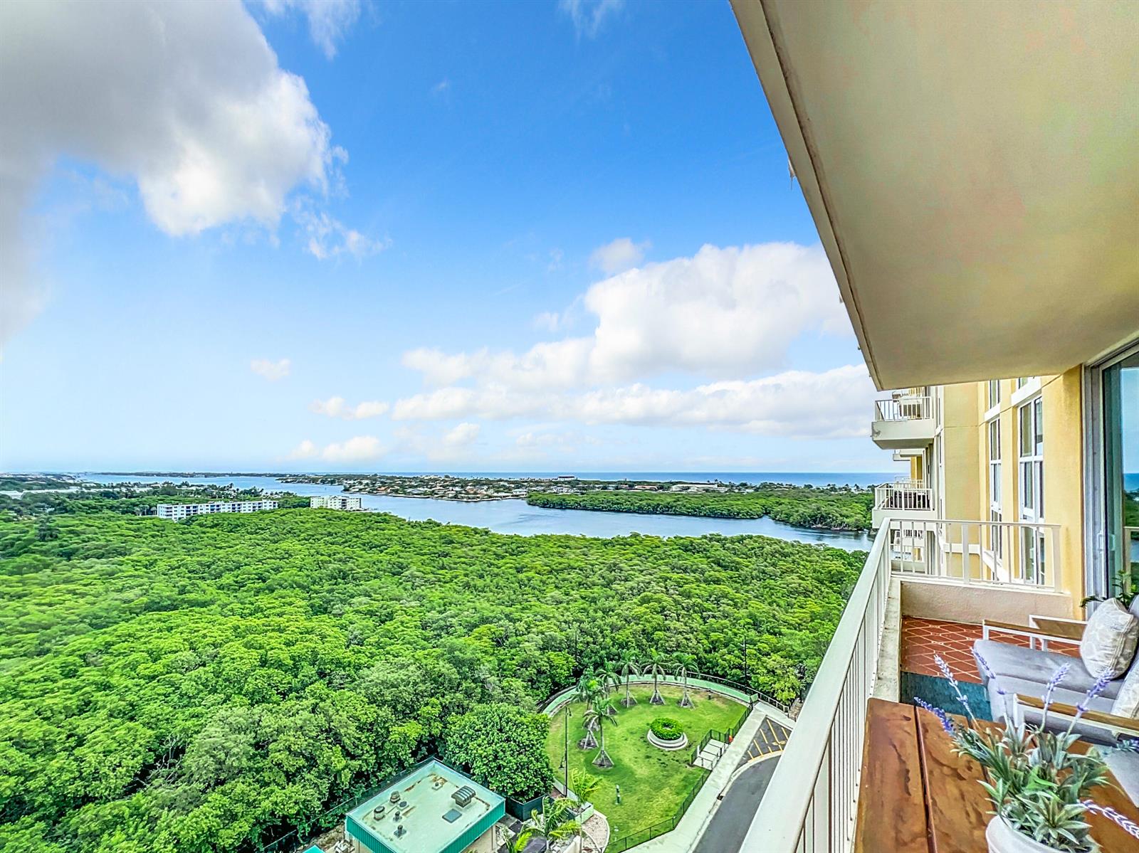 A high-angle view from a balcony overlooking a dense forest, a waterway, and the ocean — 700 E Boynton Beach Boulevard # 1408, Boynton Beach FL 33435, BOYNTON BEACH, FL