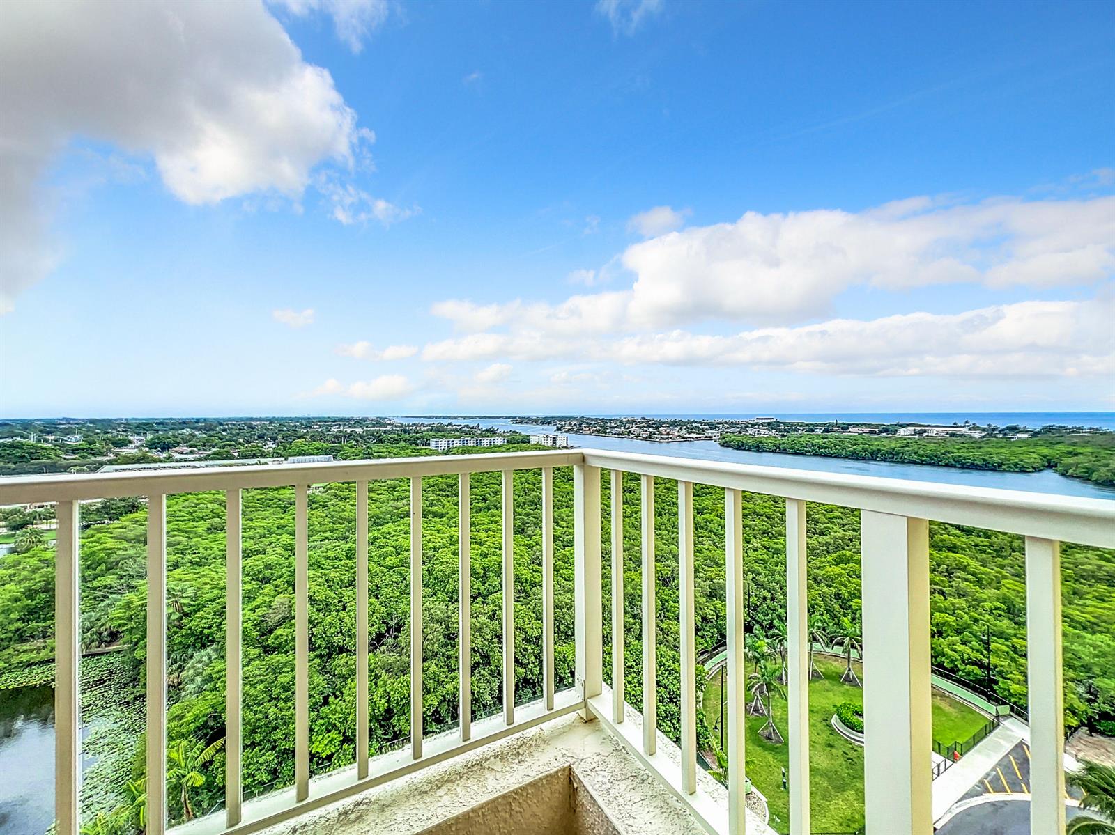 A high-angle view from a balcony overlooking a dense forest, a waterway, and the ocean — 700 E Boynton Beach Boulevard # 1408, Boynton Beach FL 33435, BOYNTON BEACH, FL