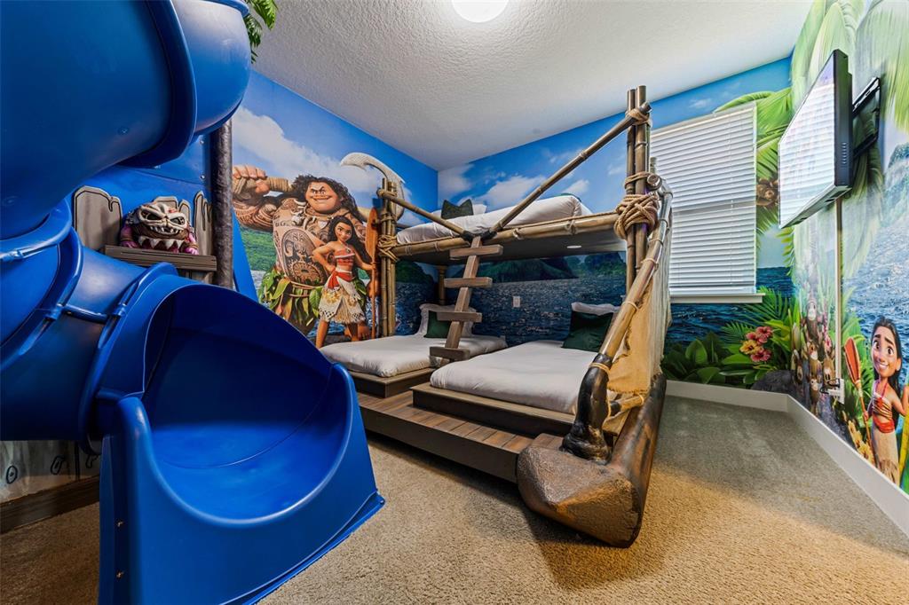 A Moana-themed bedroom features a custom bunk bed structure and a blue plastic slide — 451 LASSO DRIVE, KISSIMMEE, FL