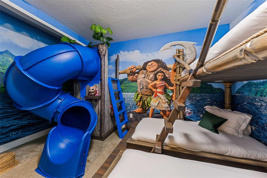 A themed bedroom features a blue spiral slide, bunk beds, and a Moana wall mural — 451 LASSO DRIVE, KISSIMMEE, FL