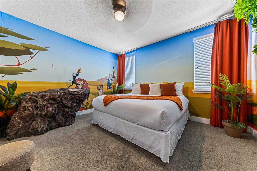 A bedroom features a Lion King-themed mural, a large rock sculpture, and a queen bed — 451 LASSO DRIVE, KISSIMMEE, FL