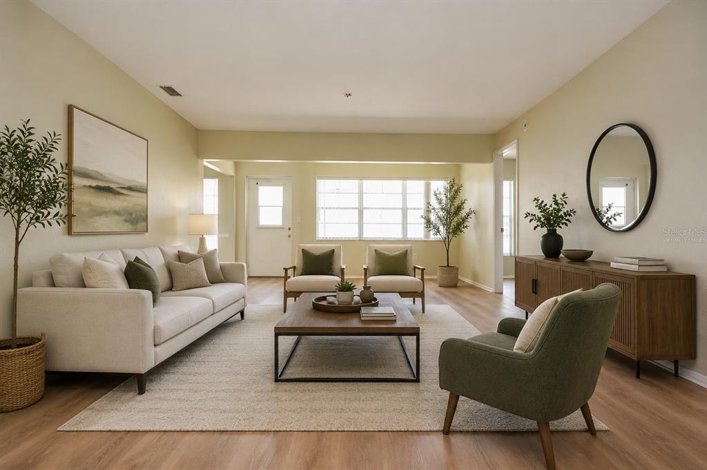 A living room features a sofa, two armchairs, a coffee table, and light wood flooring — 9027 WARWICK LANE, NEW PORT RICHEY, FL