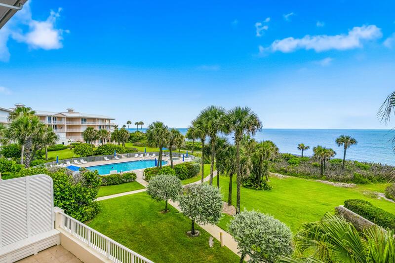 An elevated view shows a swimming pool, palm trees, and a grassy lawn by the ocean — VERO BEACH, FL
