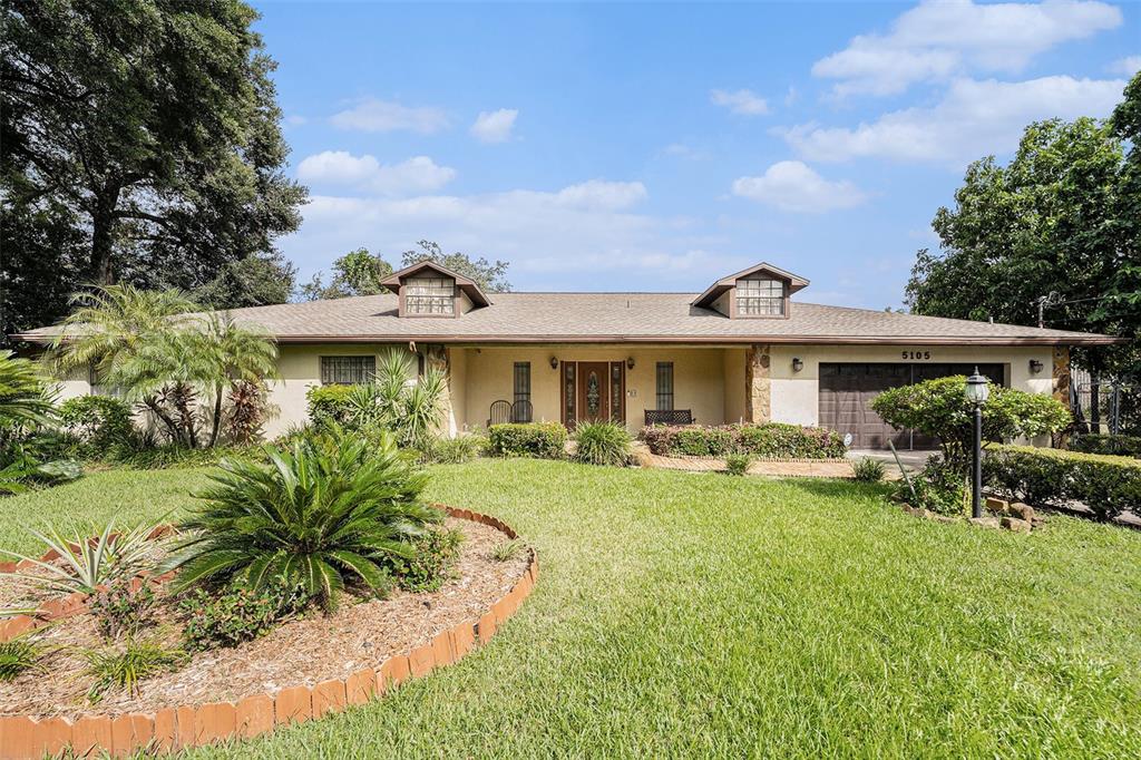 A single-story house with a brown roof, two dormers, and a front-facing garage — 5105 N 45TH STREET, TAMPA, FL