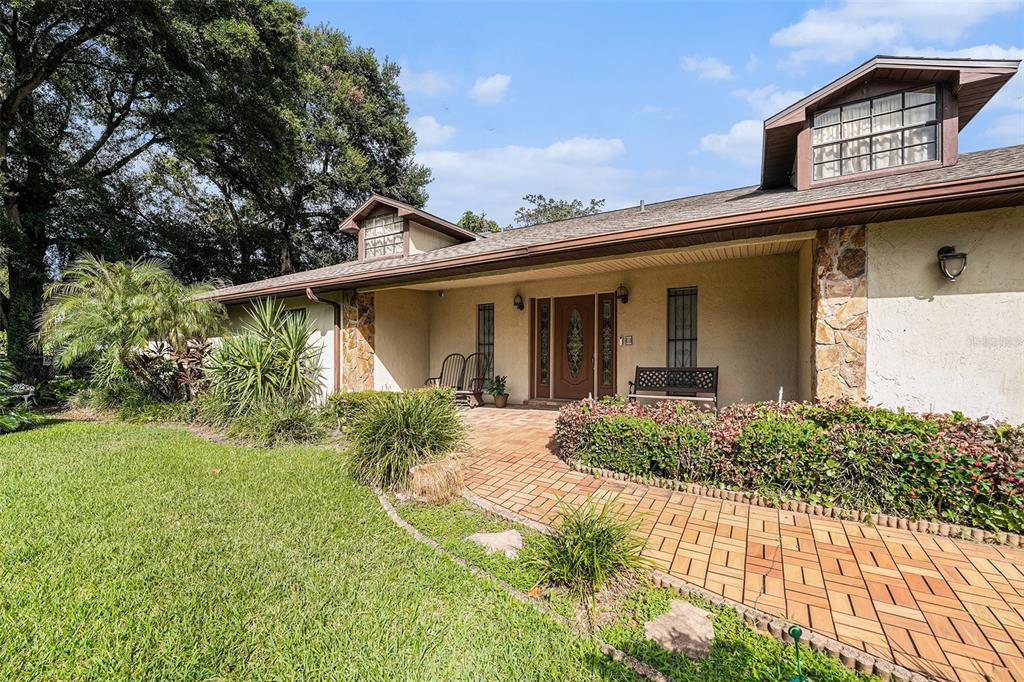 A single-story house with a brick walkway leading to a covered front porch entrance — 5105 N 45TH STREET, TAMPA, FL