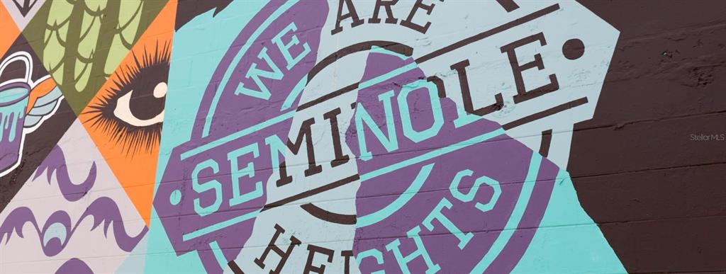A colorful mural on a brick wall features the words We Are Seminole Heights — 5530 N 9TH STREET UNIT 3, TAMPA, FL