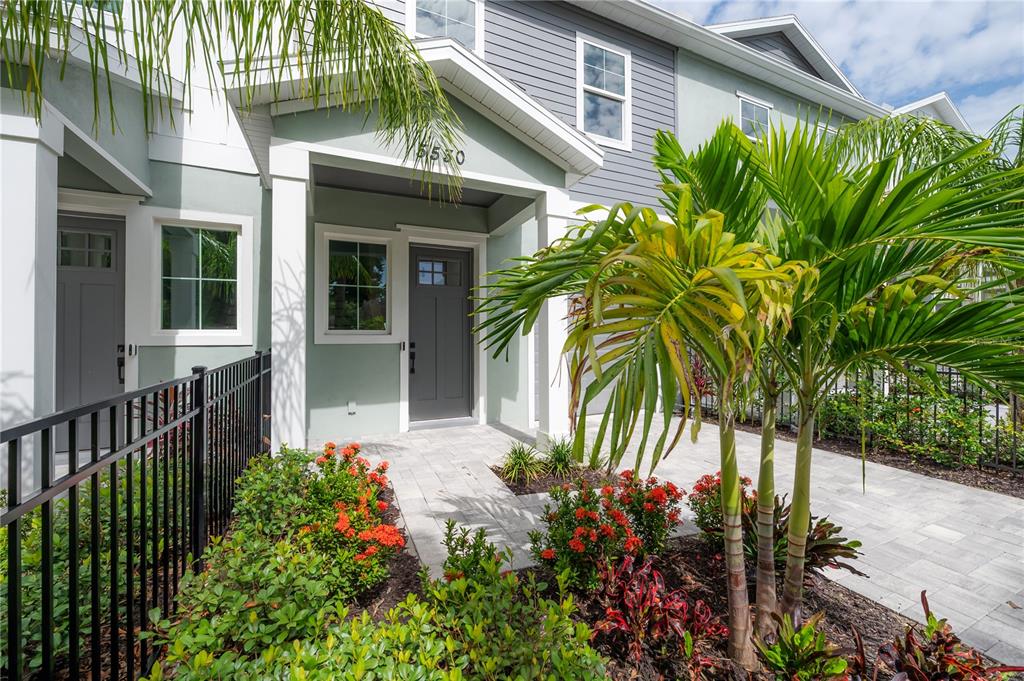 A brick walkway leads to a calm lake surrounded by lush green trees and grass — 5530 N 9TH STREET UNIT 3, TAMPA, FL