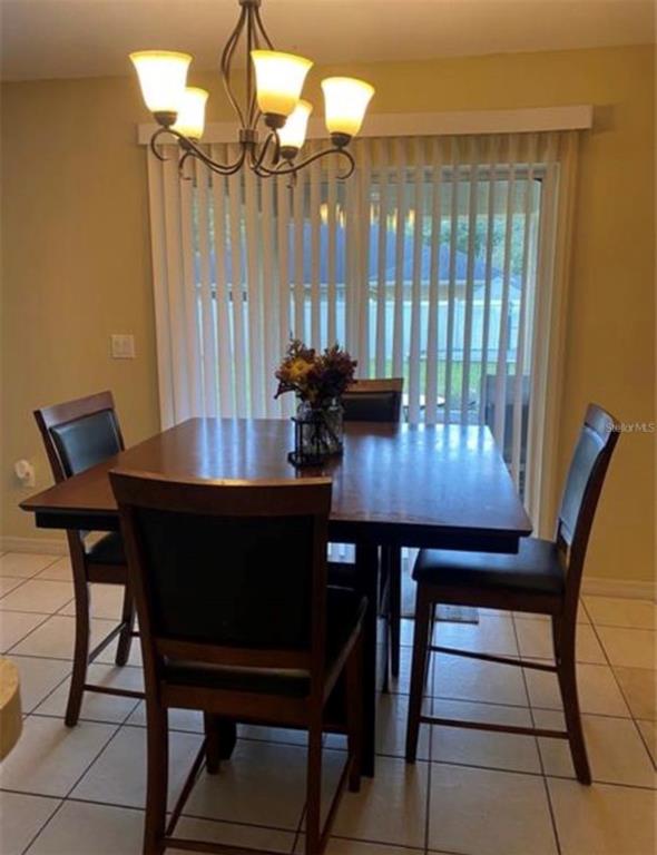 A kitchen features light wood cabinets, a stainless steel microwave and stove, and tile flooring — 8040 SW 128TH LOOP, OCALA, FL