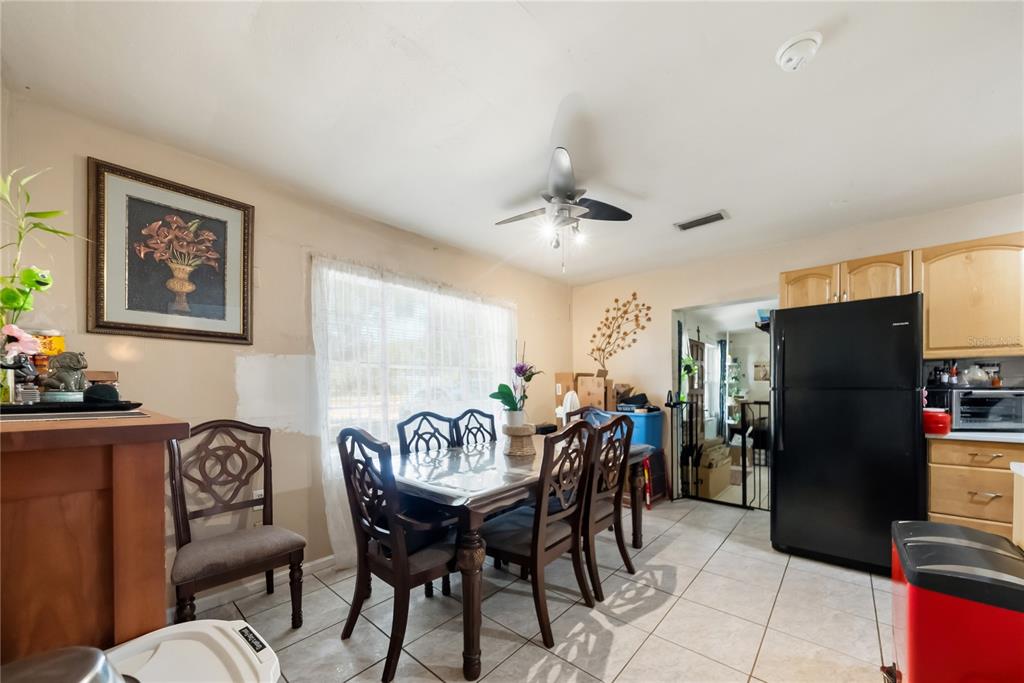 A dining area features a dark wood table with chairs, tile flooring, and a ceiling fan — 761 SEMINOLA BOULEVARD, CASSELBERRY, FL