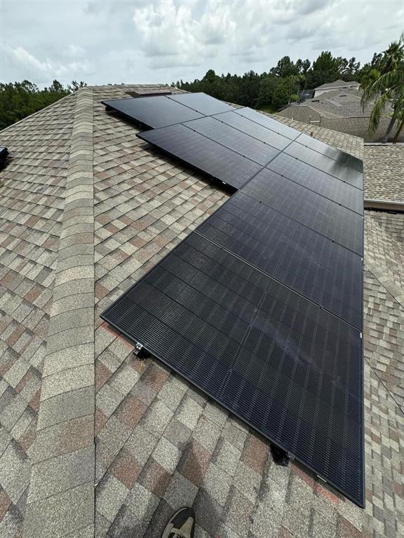A high-angle view shows solar panels installed on a shingled residential roof — 2912 SUNSET LAKES BOULEVARD, KISSIMMEE, FL