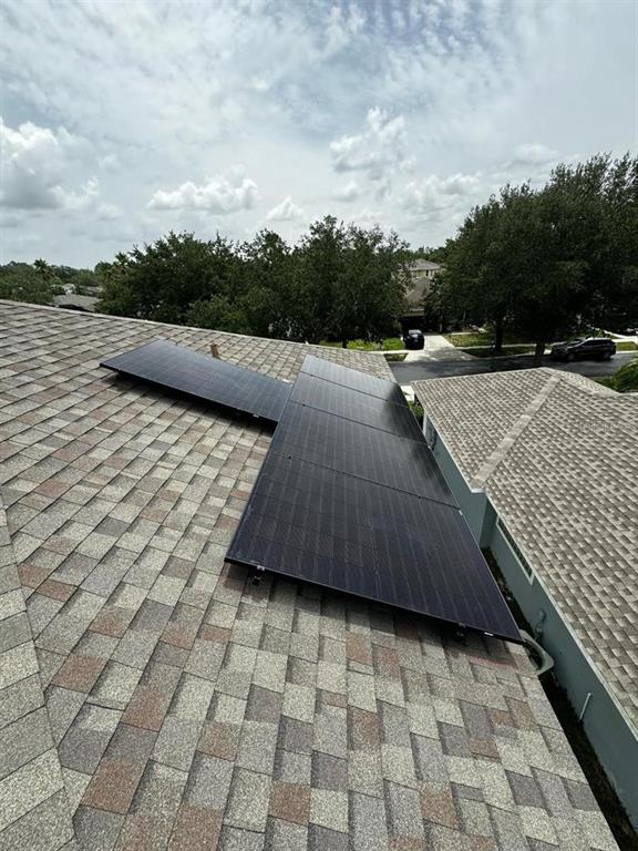 Solar panels are installed on the shingled roof of a residential home — 2912 SUNSET LAKES BOULEVARD, KISSIMMEE, FL