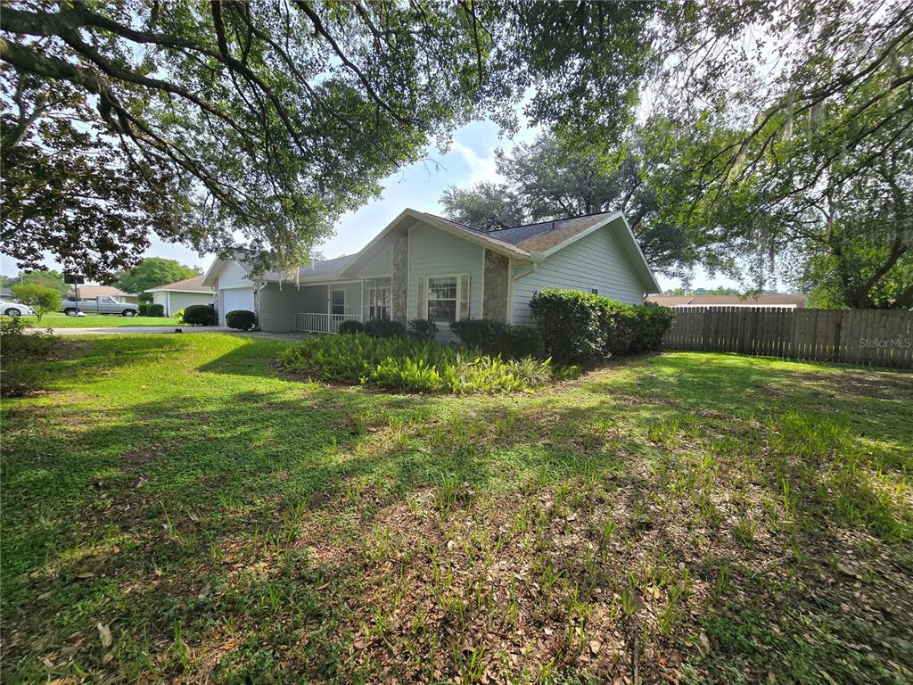 A light-colored single-story house with a stone accent wall and a large front yard — 5655 SE 42ND AVENUE, OCALA, FL