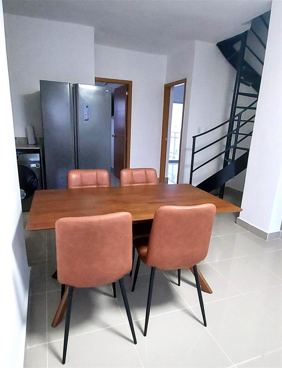 A dining area features a wooden table, four tan chairs, a refrigerator, and a staircase — Calle 6 Calle 6, Punta Del Este 2 # C301, FL