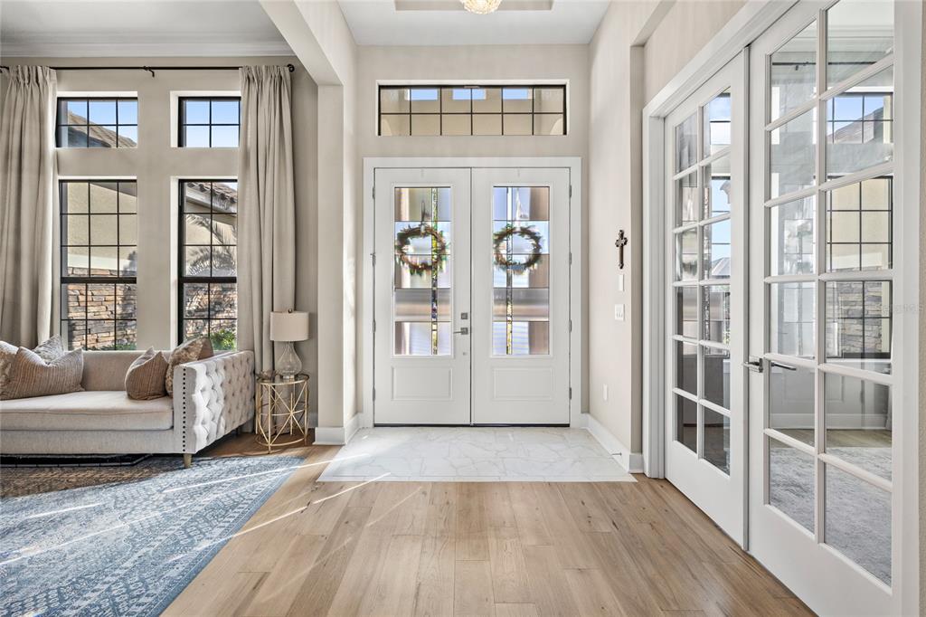 A bright entryway features double front doors, a marble floor inlay, and light wood flooring — 25620 GRANDVIEW POINTE, SORRENTO, FL