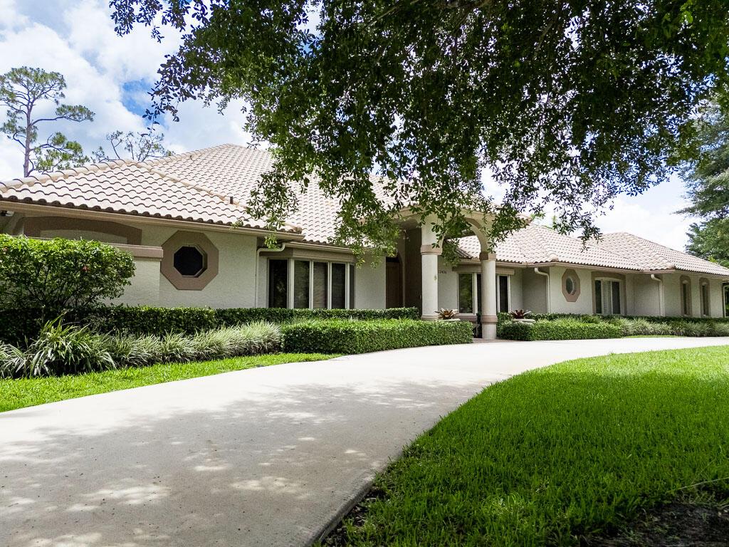 A single-story house with a tiled roof, stucco exterior, and a curved concrete driveway — 13406 Doubletree Circle, Wellington FL 33414, WELLINGTON, FL