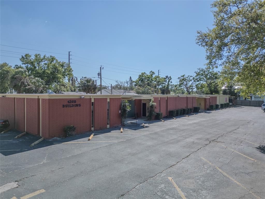 A single-story red brick commercial building features a flat roof and an adjacent asphalt parking lot — 4200 CENTRAL AVENUE S, ST PETERSBURG, FL
