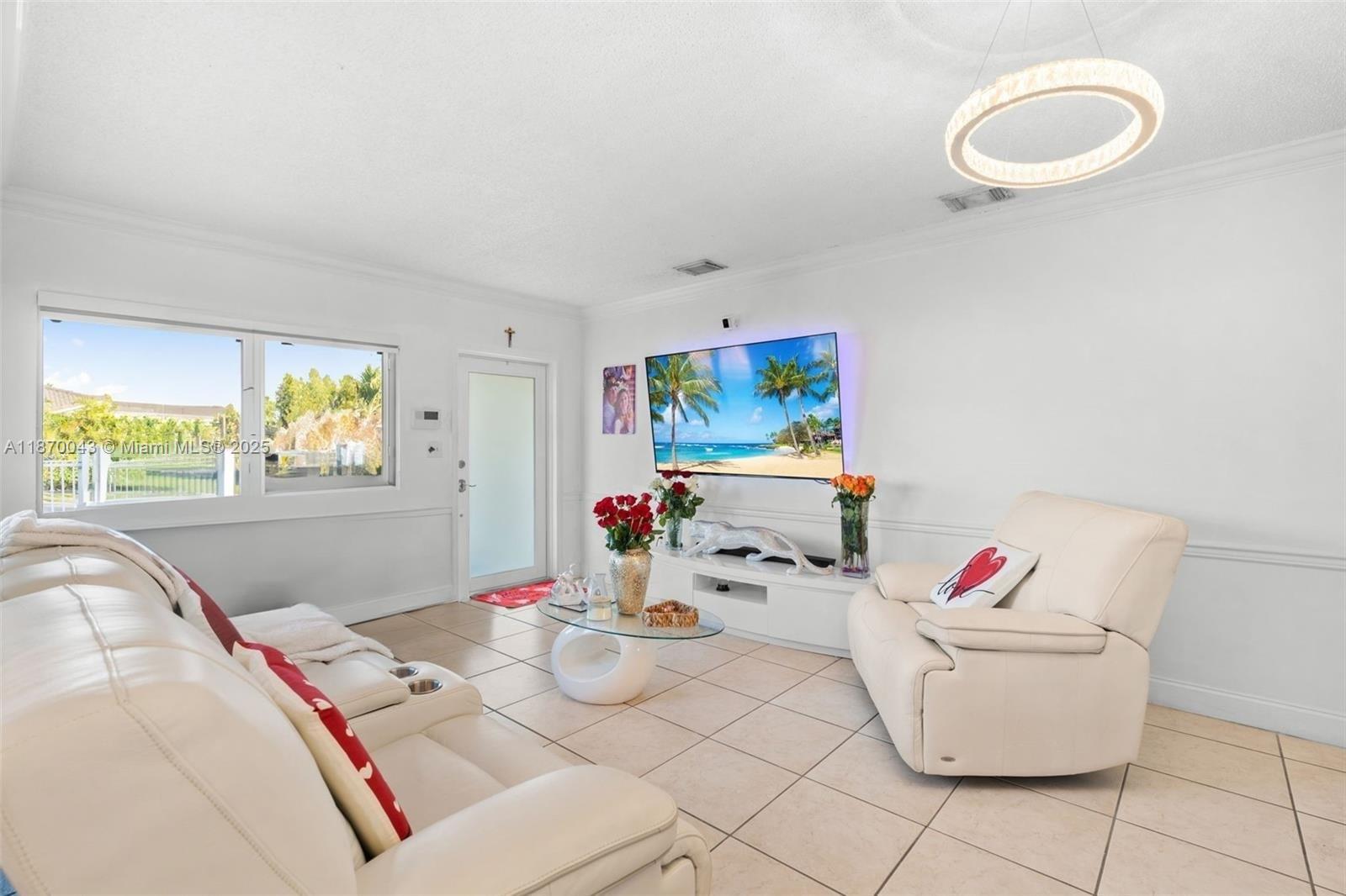 A living room features white leather furniture, a wall-mounted television, and a circular ceiling light — 17874 SW 114th Ave, Miami FL 33157, MIAMI, FL