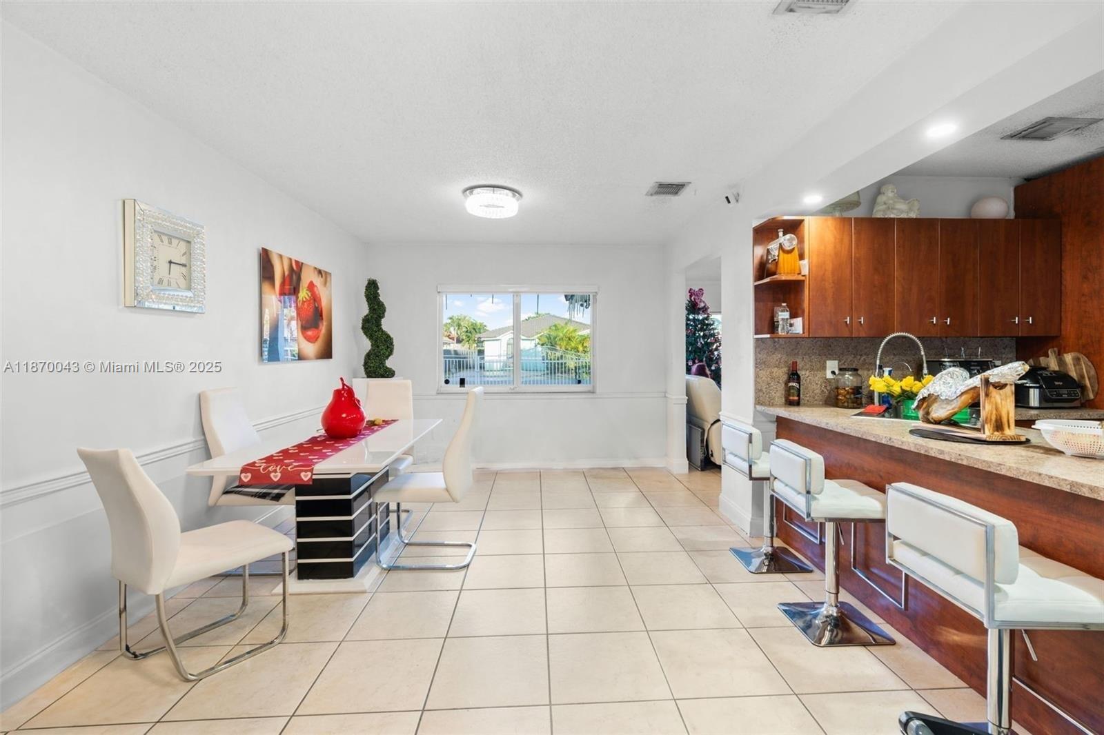 A dining area with a modern table and chairs sits adjacent to a kitchen counter — 17874 SW 114th Ave, Miami FL 33157, MIAMI, FL