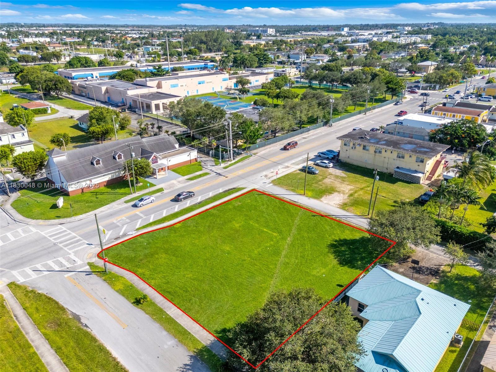 An aerial view shows a vacant, rectangular grass lot outlined in red at a street intersection — 604 SW 6th Ave, Homestead FL 33030, HOMESTEAD, FL