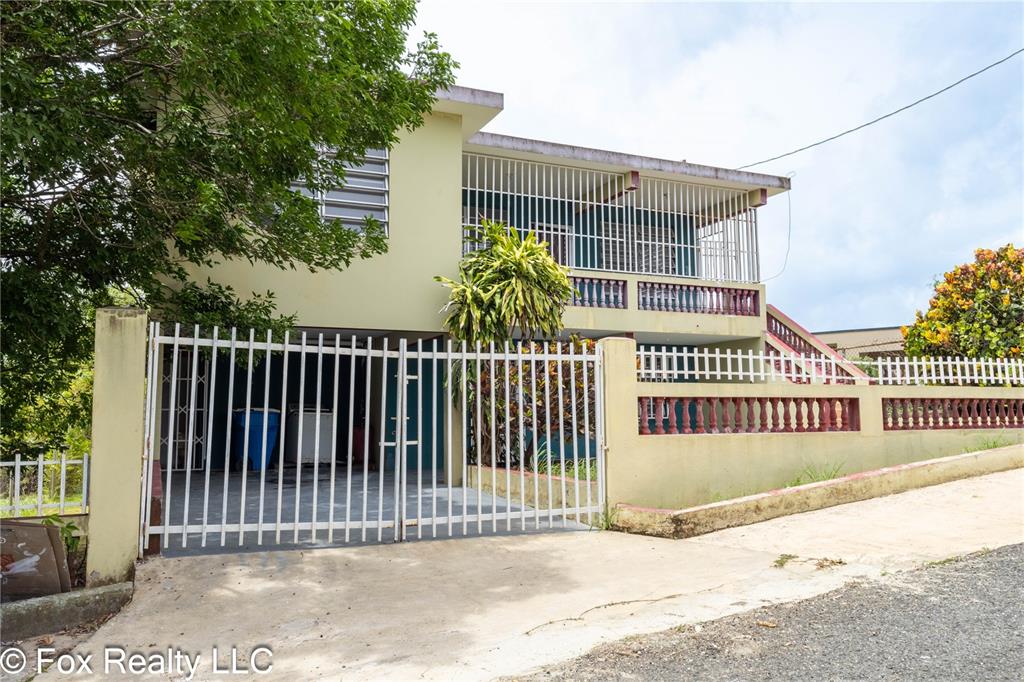 A two-story house features a gated driveway, a balcony with metal railings, and exterior stairs — Solar B AVENIDA MARIA BETTEGA, AGUADILLA, PR