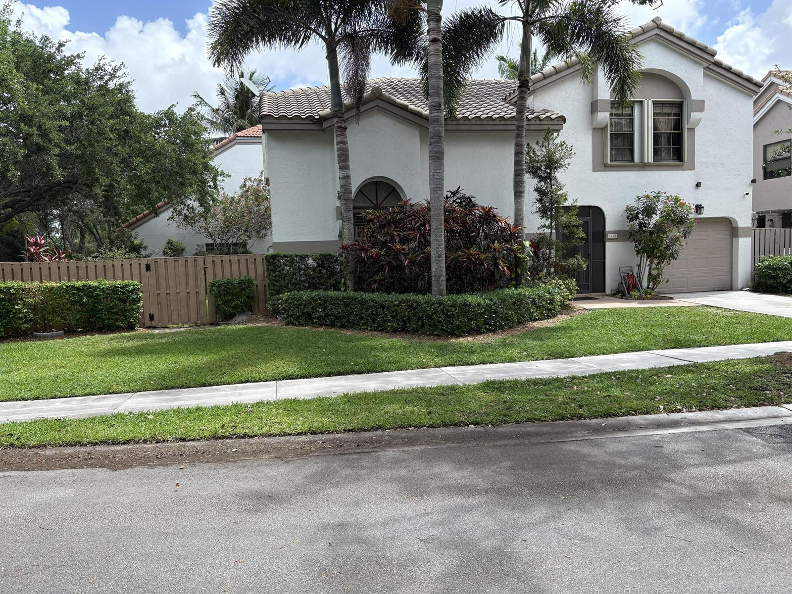 A two-story house with a tile roof, palm trees, and a manicured hedge in front — 1750 NW 107th Way, Plantation FL 33322, PLANTATION, FL