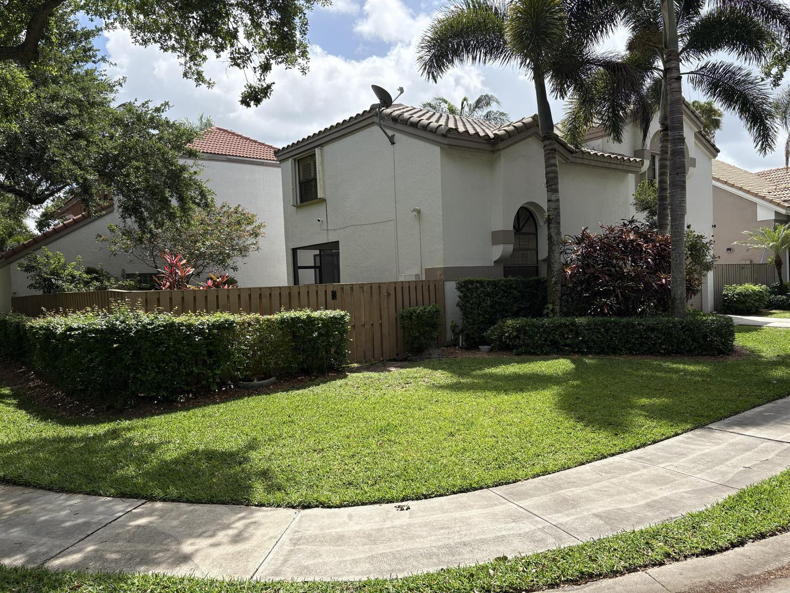 A two-story stucco house with a tile roof, wooden fence, and palm trees — 1750 NW 107th Way, Plantation FL 33322, PLANTATION, FL