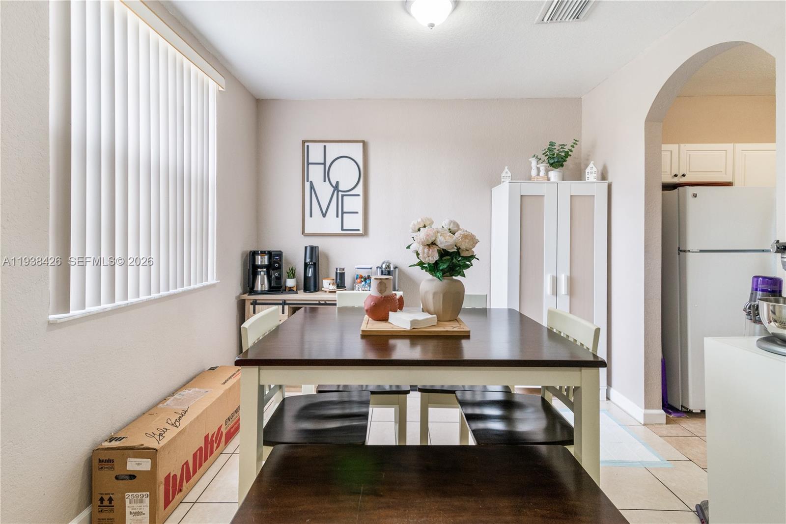 A dining room features a dark wood table, white chairs, and a tall storage cabinet — 1420 NE 33rd Ave # 15, Homestead FL 33033, HOMESTEAD, FL