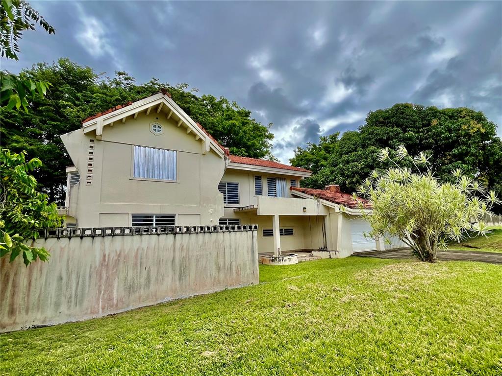 A two-story house with a beige exterior, red tile roof, and a concrete perimeter wall — Urb. Naranjo Valley #45, FAJARDO, PR