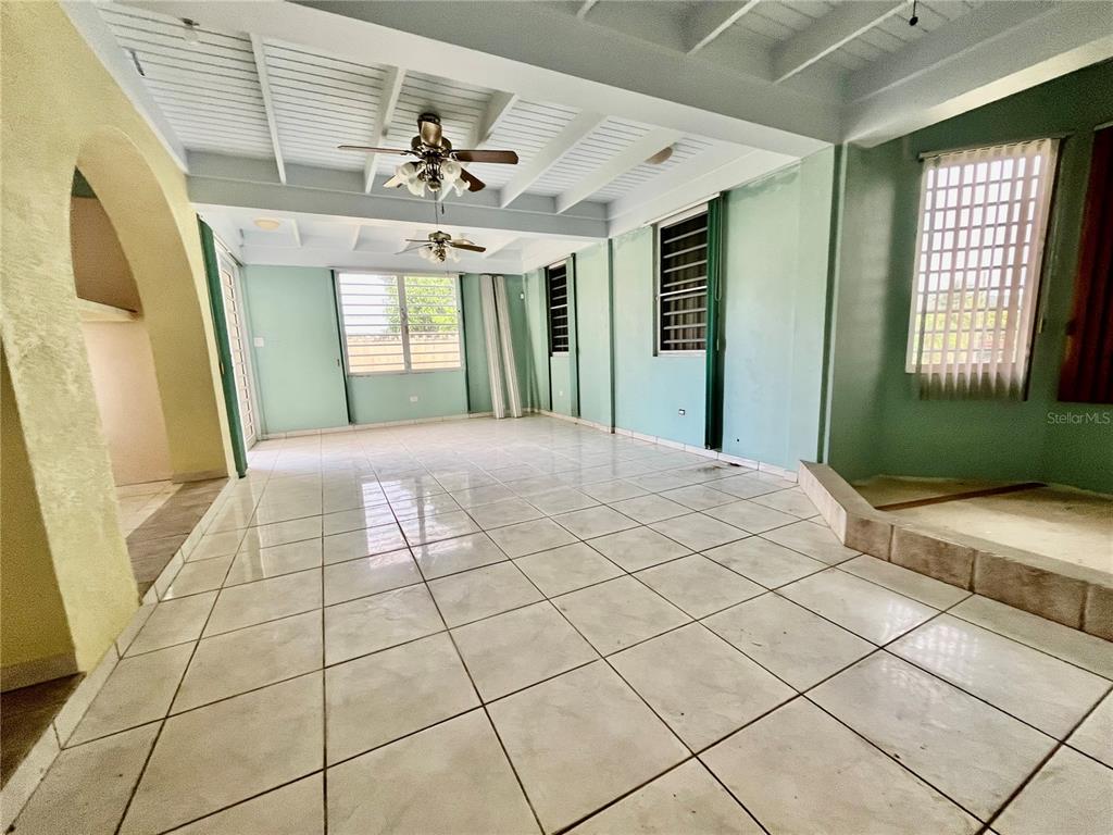 A spacious room with light green walls, white tile flooring, and a beamed ceiling — Urb. Naranjo Valley #45, FAJARDO, PR