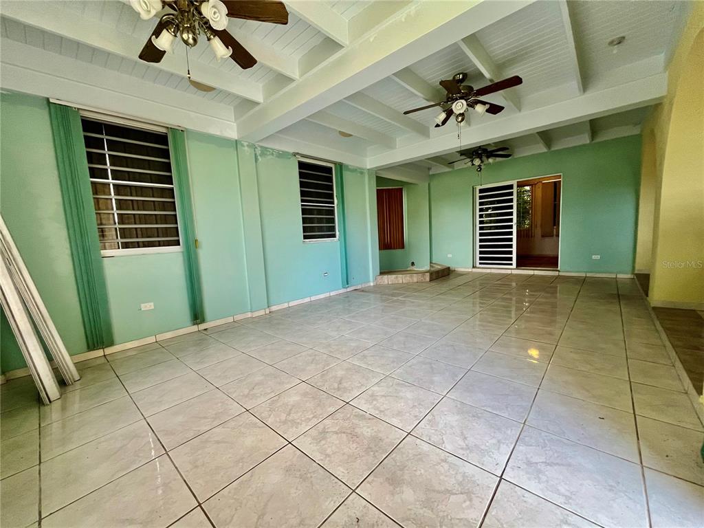 A spacious room with light green walls, tiled floors, and three ceiling fans — Urb. Naranjo Valley #45, FAJARDO, PR