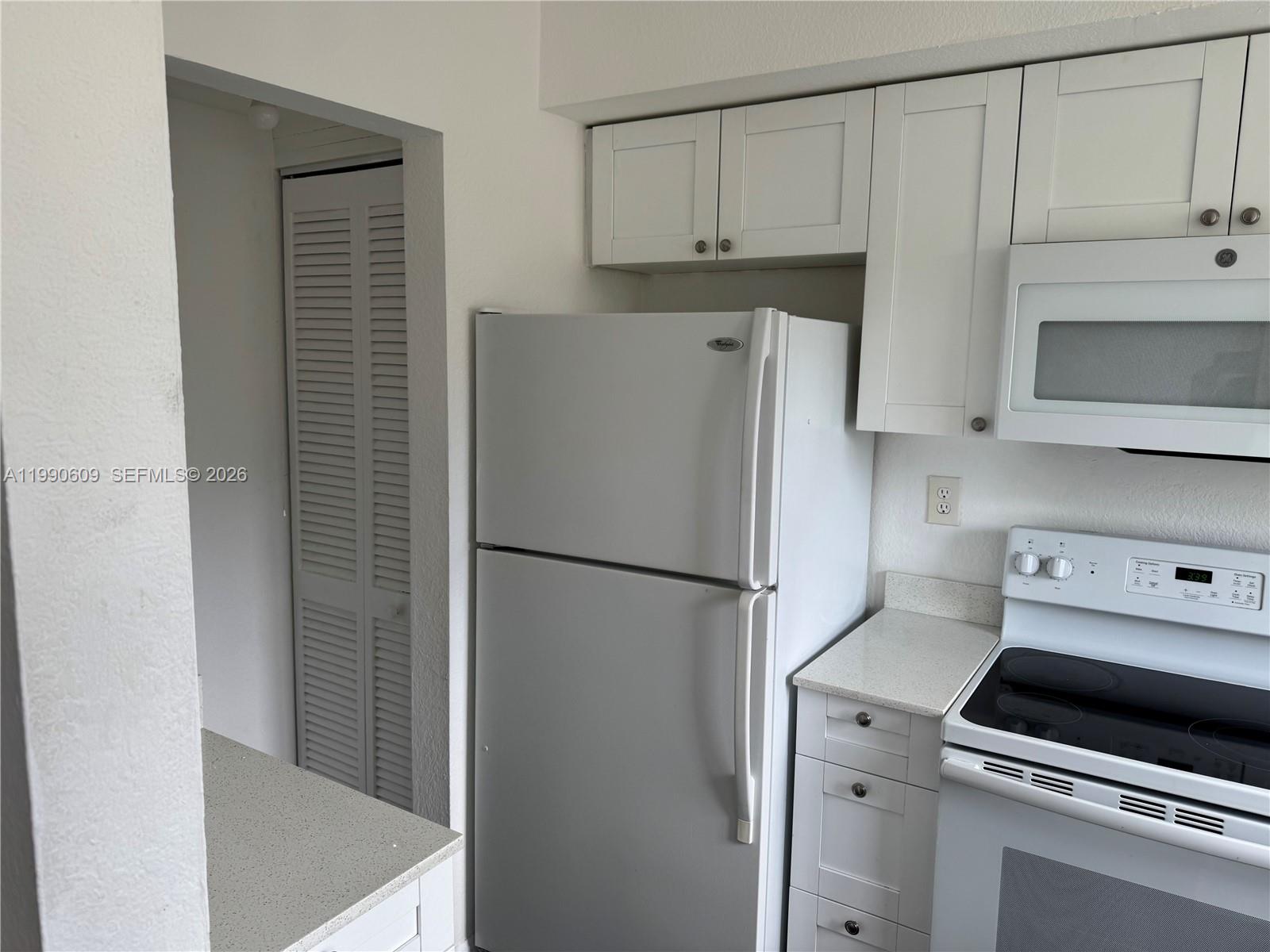 A kitchen features white cabinets, a white refrigerator, and a white electric range — 8301 NW 4th Ave # 8301C, Miami FL 33150, MIAMI, FL