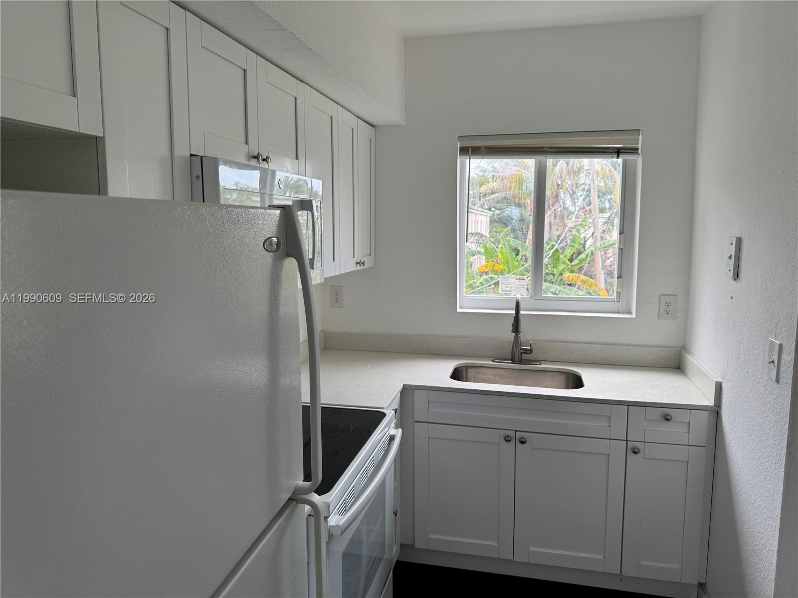 A kitchen features white cabinets, a stainless steel sink, and a white refrigerator — 8301 NW 4th Ave # 8301C, Miami FL 33150, MIAMI, FL