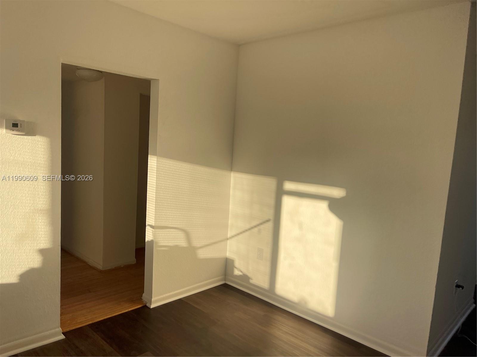 An interior view shows a room with dark wood flooring and a doorway leading elsewhere — 8301 NW 4th Ave # 8301C, Miami FL 33150, MIAMI, FL