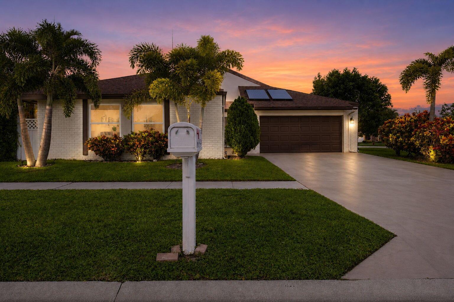 A single-story white brick house with a driveway and palm trees at sunset — 11455 Whisper Sound Drive, Boca Raton FL 33428, BOCA RATON, FL