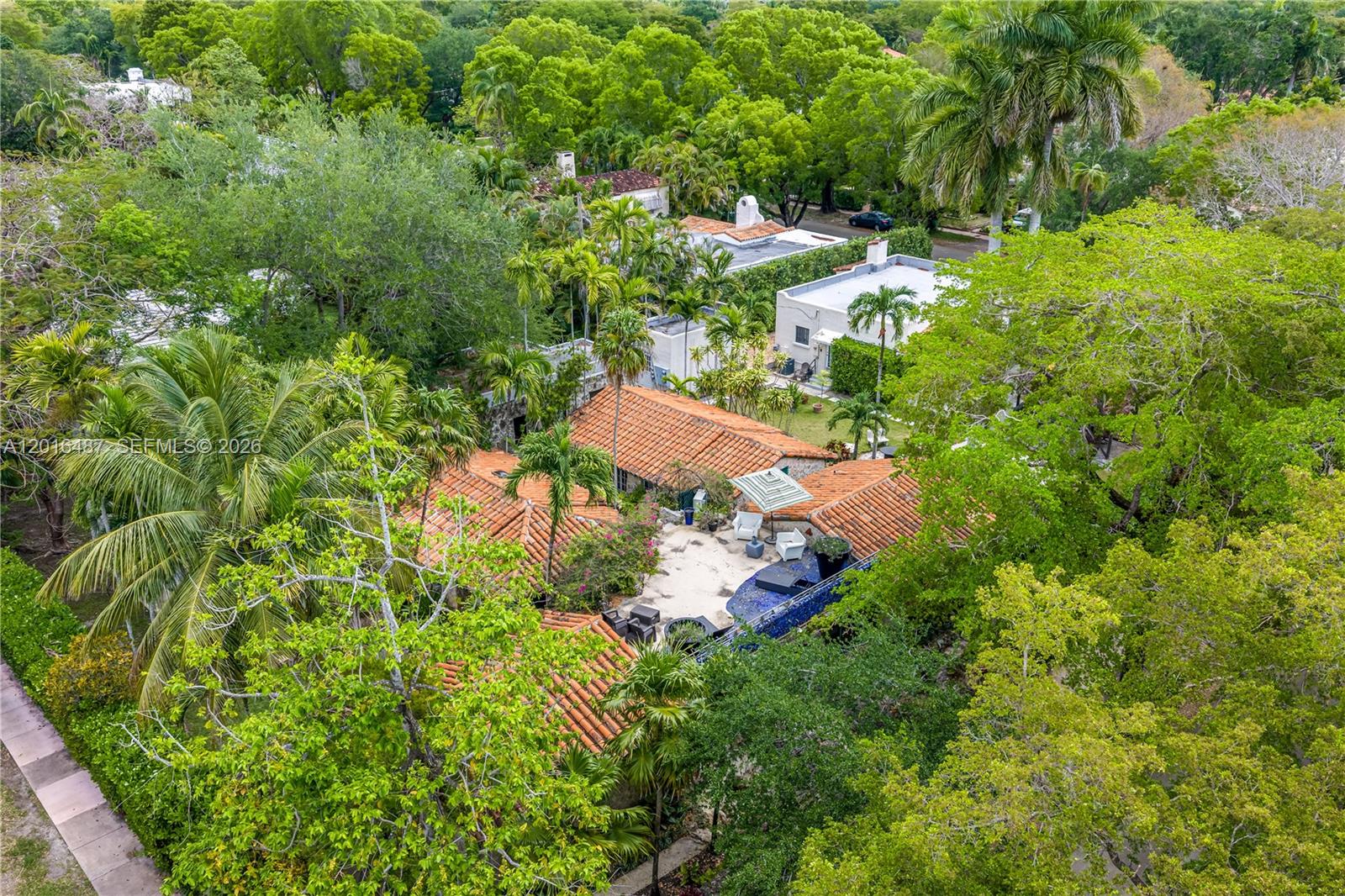 An aerial view shows a house with a terracotta tile roof and a backyard pool — 1301 Milan Ave # 3, Coral Gables FL 33134, CORAL GABLES, FL