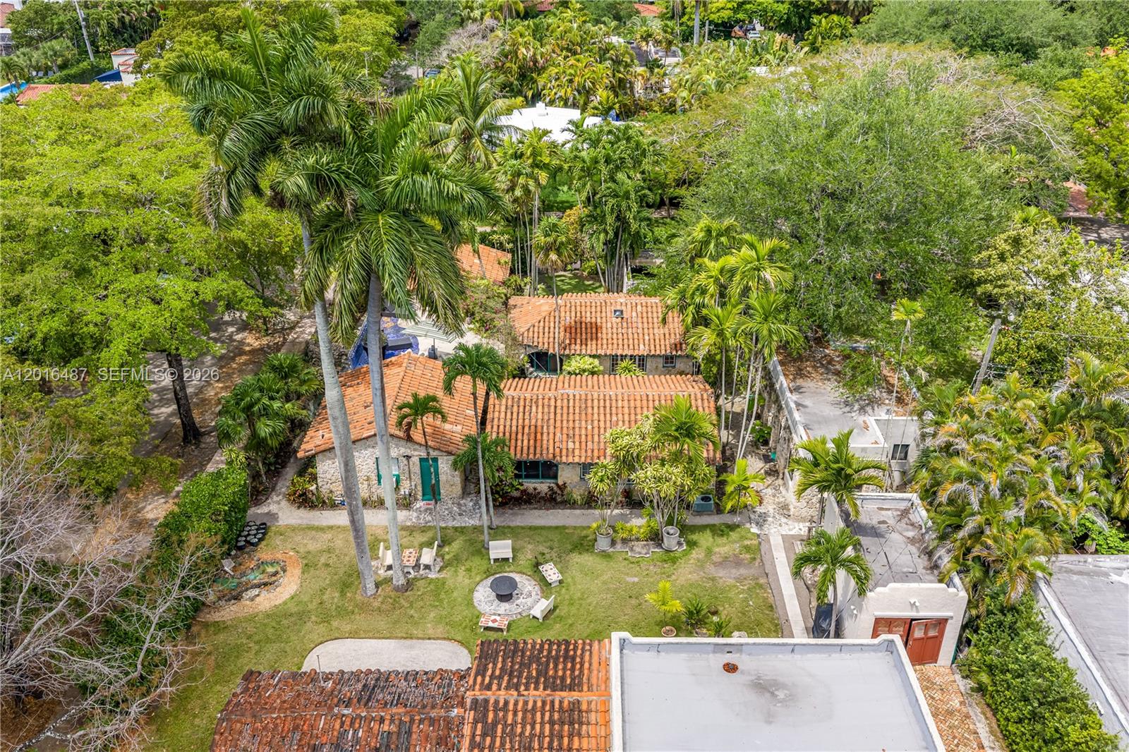 An aerial view shows a stone house with a terracotta tile roof and backyard — 1301 Milan Ave # 3, Coral Gables FL 33134, CORAL GABLES, FL