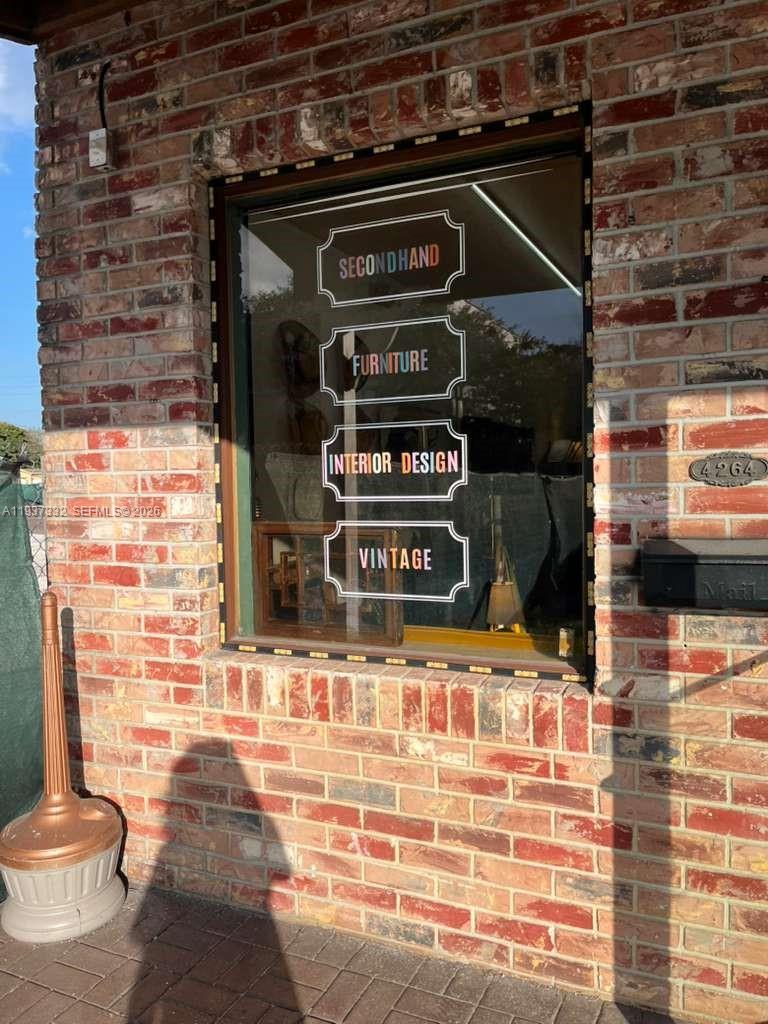 A brick exterior wall features a window with signs advertising secondhand furniture, interior design, and vintage — 4264 SW 64th Ave, Davie FL 33314, DAVIE, FL