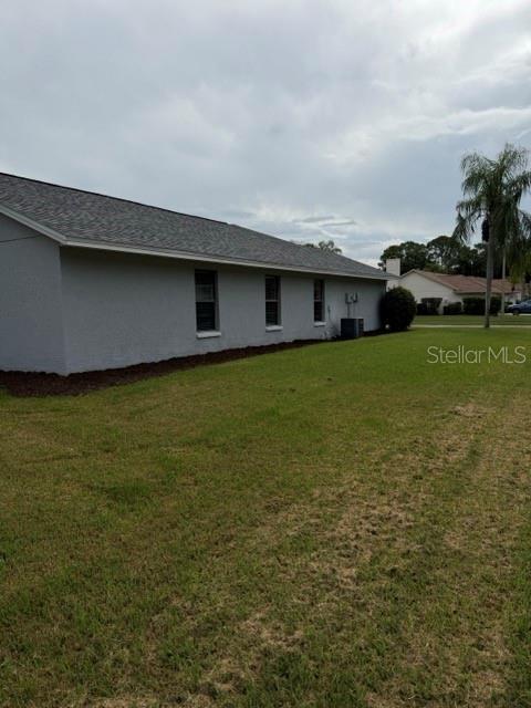The exterior of a gray, single-story house with a shingled roof and a grassy yard — 588 HOLLOWTREE PLACE, TARPON SPRINGS, FL