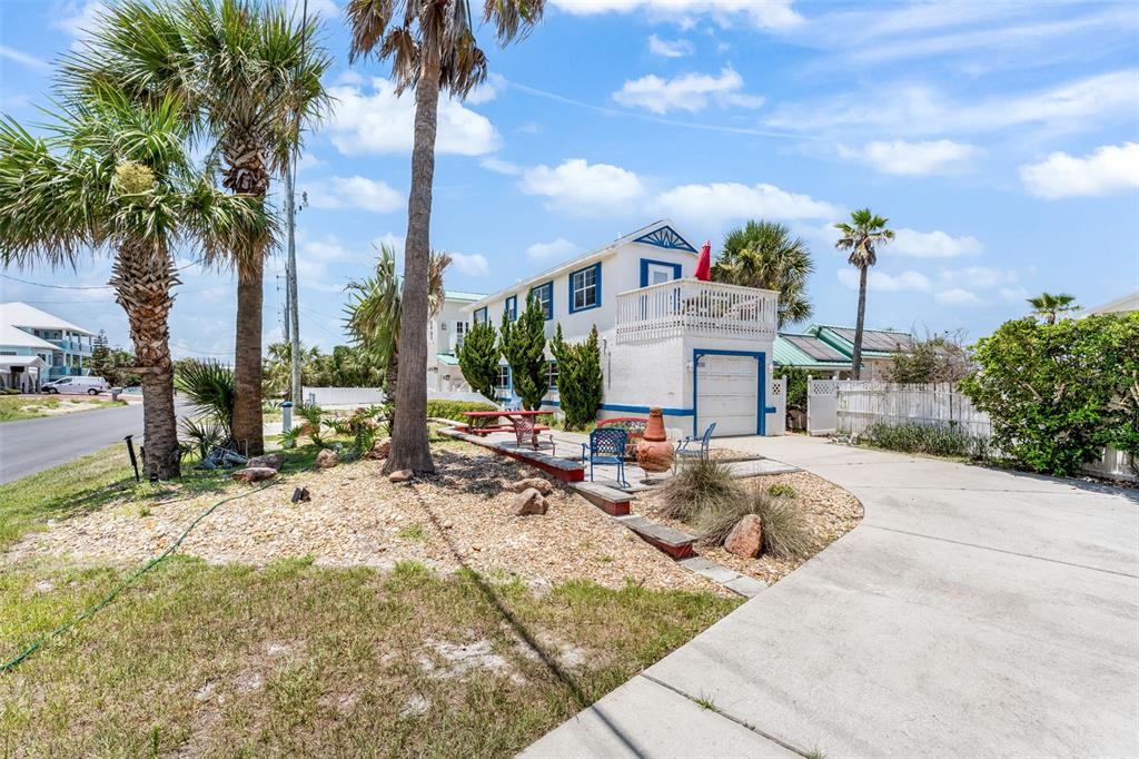 A two-story white house with blue trim features a garage and an upper-level deck — 2347 S CENTRAL AVENUE, FLAGLER BEACH, FL