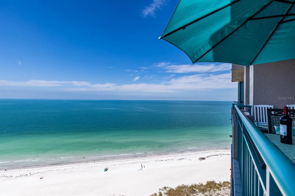 A high-angle view from a balcony overlooking a white sand beach and the ocean — 1560 GULF BOULEVARD UNIT 1605, CLEARWATER BEACH, FL