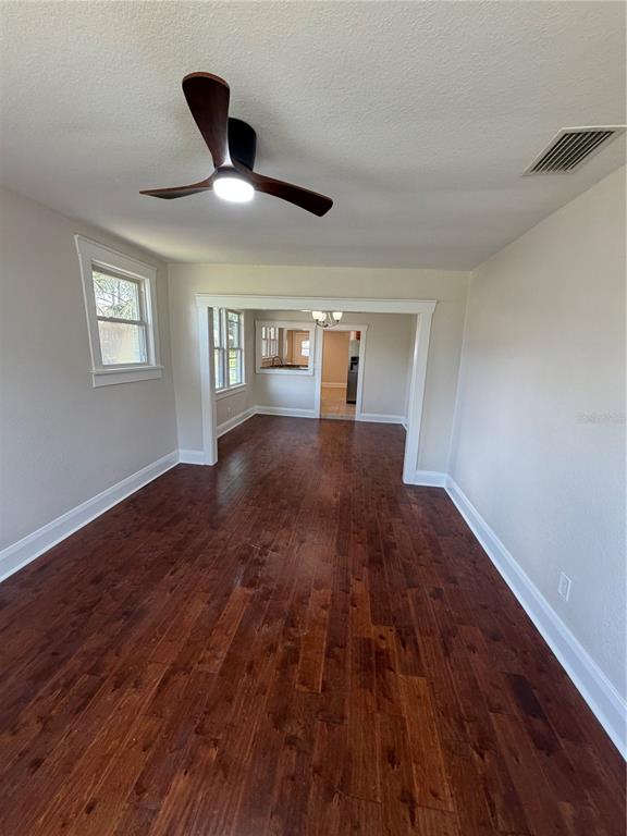 A living room with dark hardwood floors, a ceiling fan, and an open doorway — 919 W PLYMOUTH STREET, TAMPA, FL